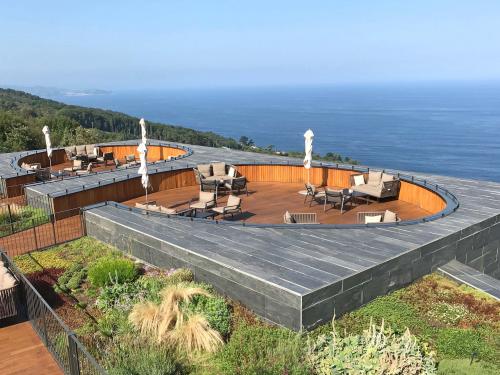 Terraces surrounded by vegetation and a view over the sea.